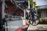 Mädchen läd ihr Rad auf den Anhänger am Fahrrradbus auf.