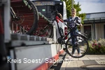 Mädchen läd ihr Rad auf den Anhänger am Fahrrradbus auf.