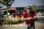 Mann steht mit Fahrrad vor Fahrradbus
